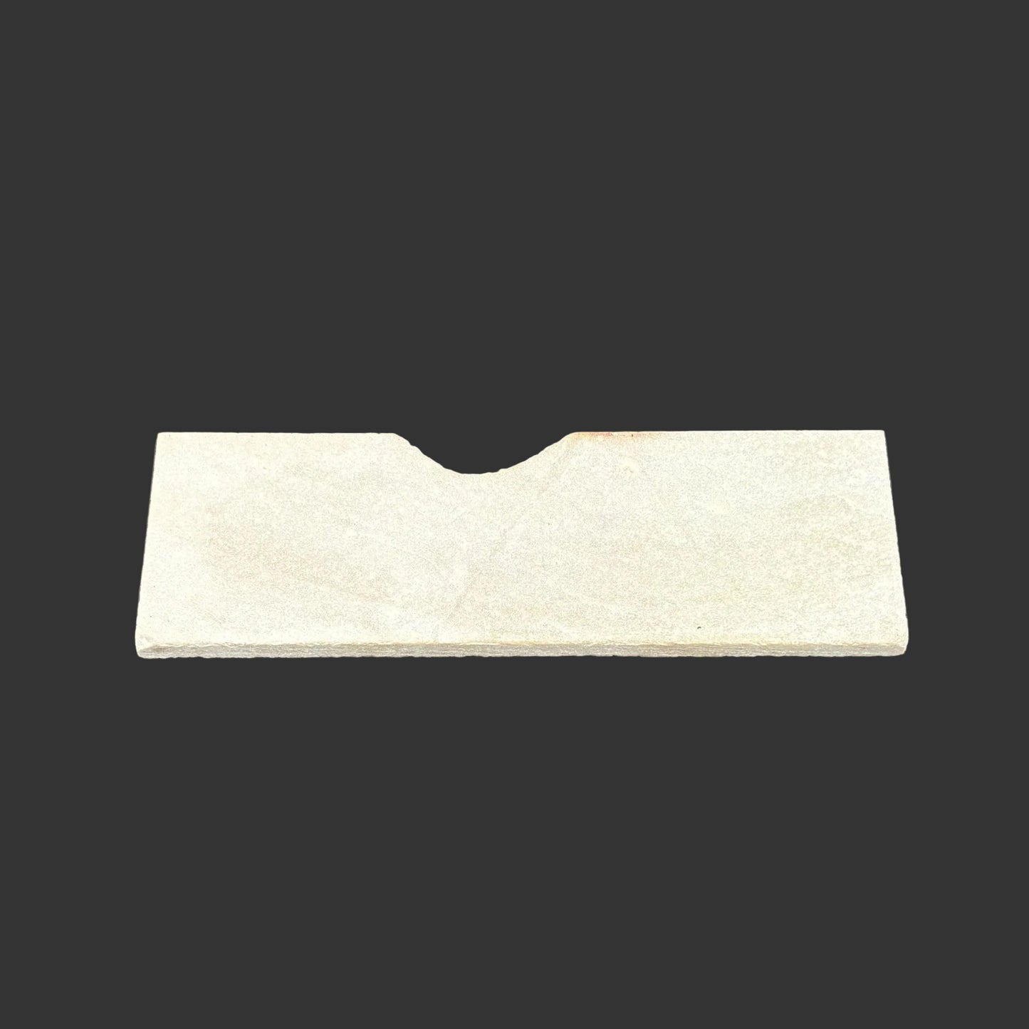 This is the back side of this novaculite sharpening stone, in front of a black backgrund.