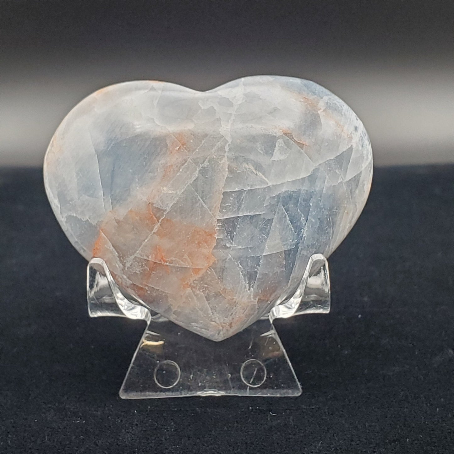 Calcite Carved Heart Polished 2 inch Blue on a plastic display stand