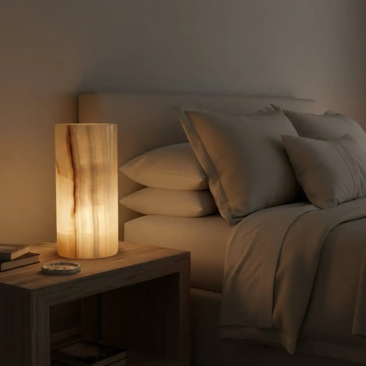 Round Onyx cylinder lamp on a bedside table, in a dim lite bedroom.