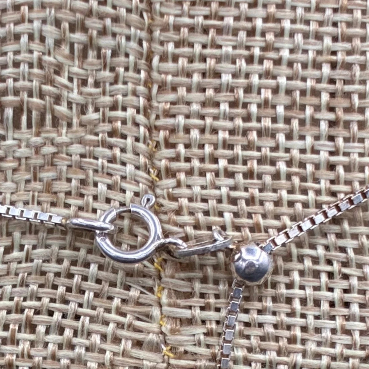 This necklace has a spring clasp, and the sterling silver necklace is adjustable.