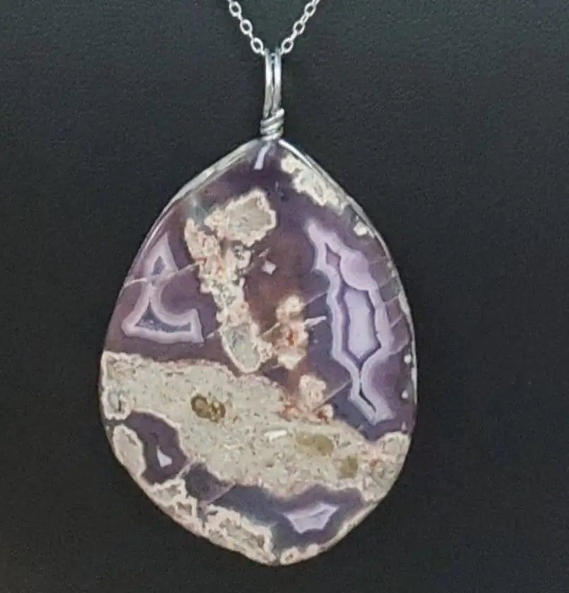Necklace with a teardrop-shaped pendant on a black mannequin