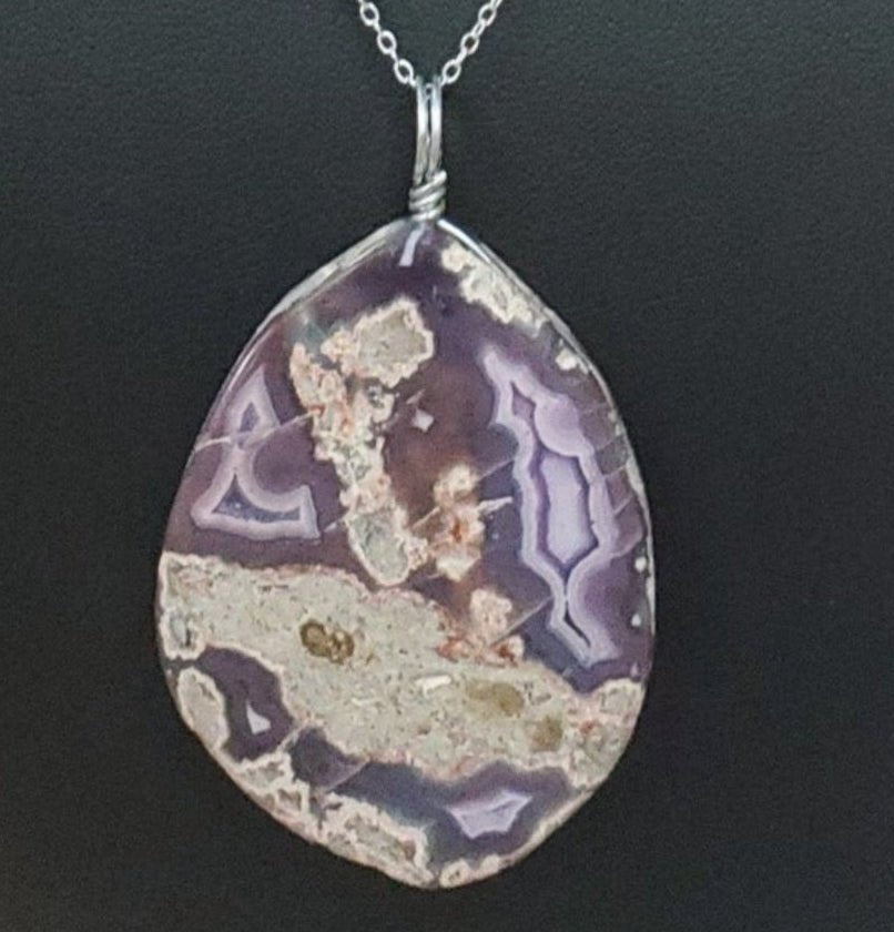 Necklace with a teardrop-shaped pendant on a black mannequin