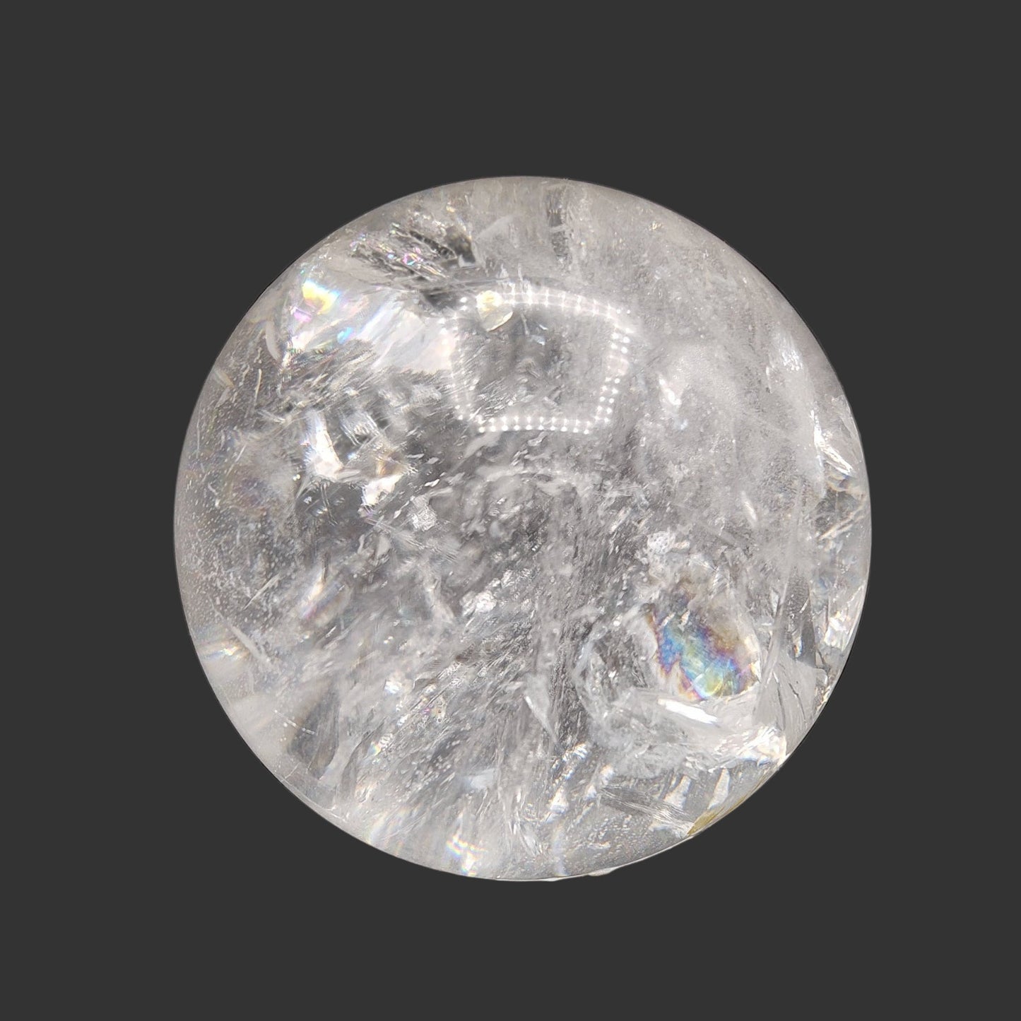 This is the right side of this polished clear quartz crystal ball. There is a small rainbow of color on the bottom right side.
