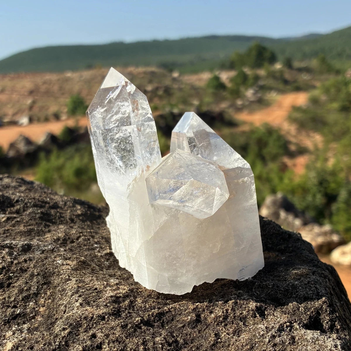 This is the right side of this quartz crystal cluster, on a rock outdoors.