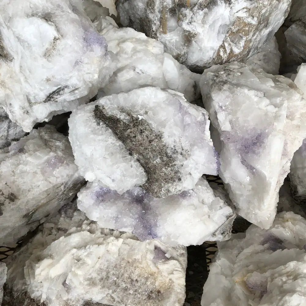 Purple Fluorite On Selenite Uncut Stone on a table