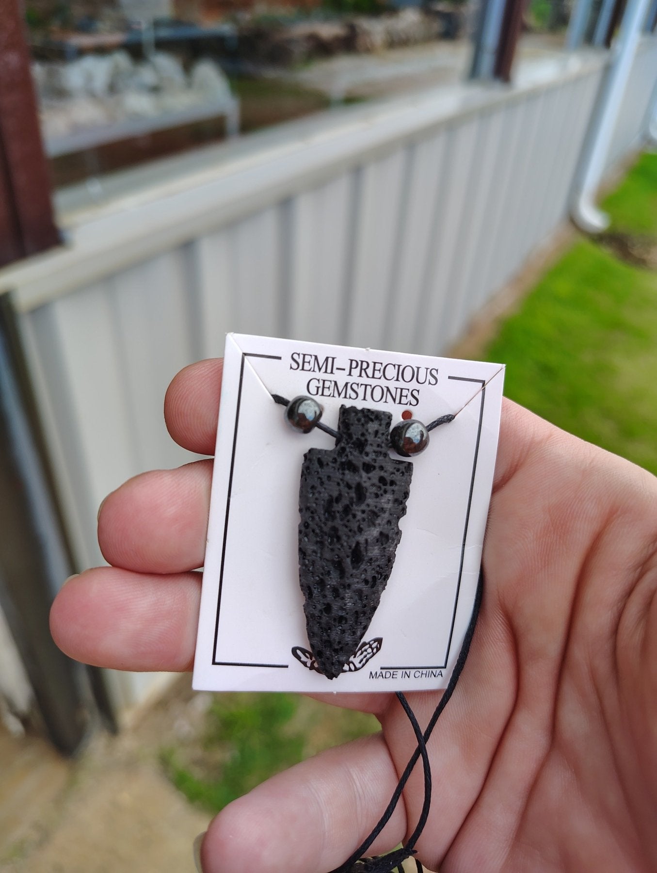 Black Lava Arrowhead necklace on white display card