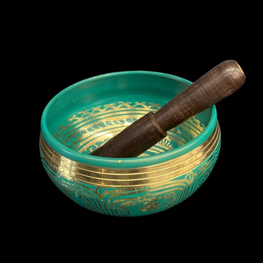 Darker Green Singing Bowl with brass accents and brass chakra symbols and a wooden striking stick inside the bowl.