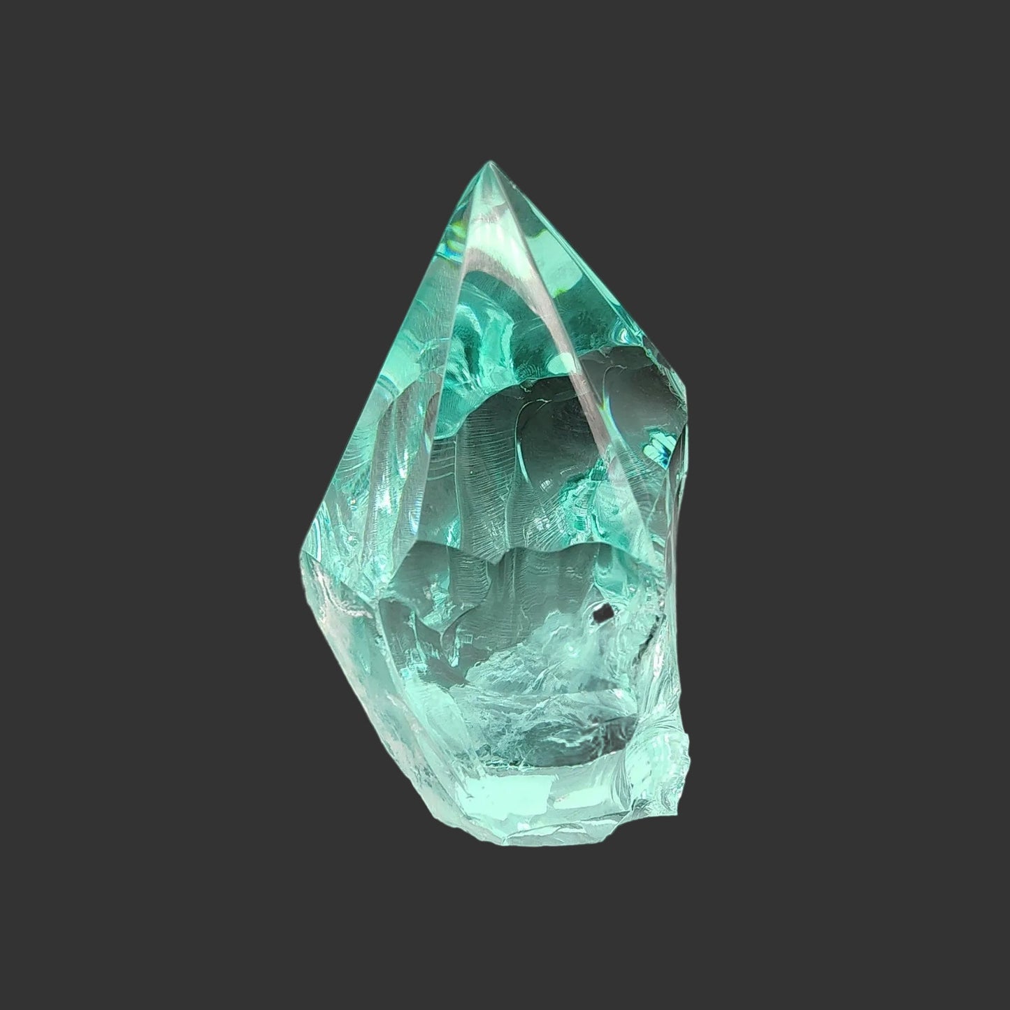 This is the right side of this hand-carved blue green Obsidian freeform.