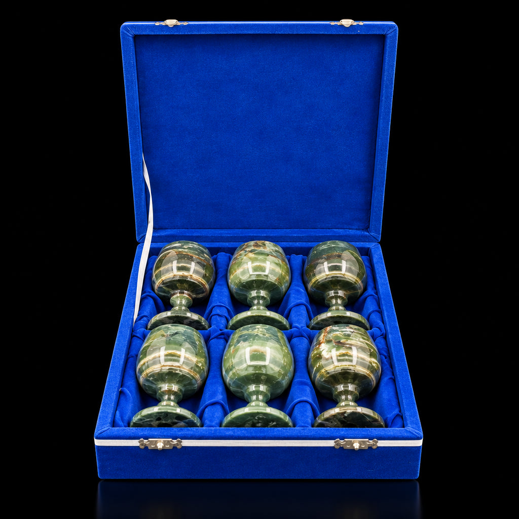 The blue velvet case opened with the sherry glasses inside it, and in front of a black background.