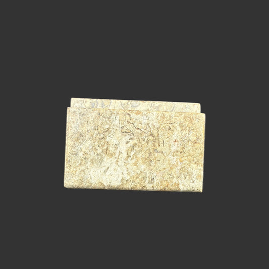 Front view of this fossil onyx card holder, in front of a black background.