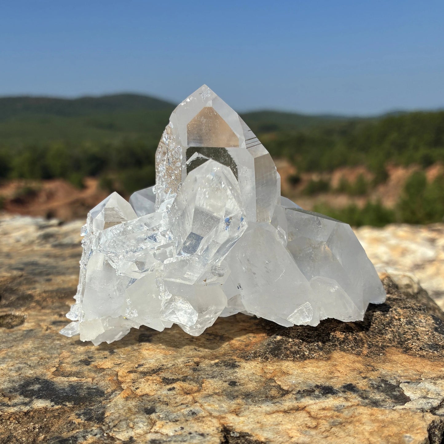 Front side of this quartz crystal cluster, on a rock outdoors.
