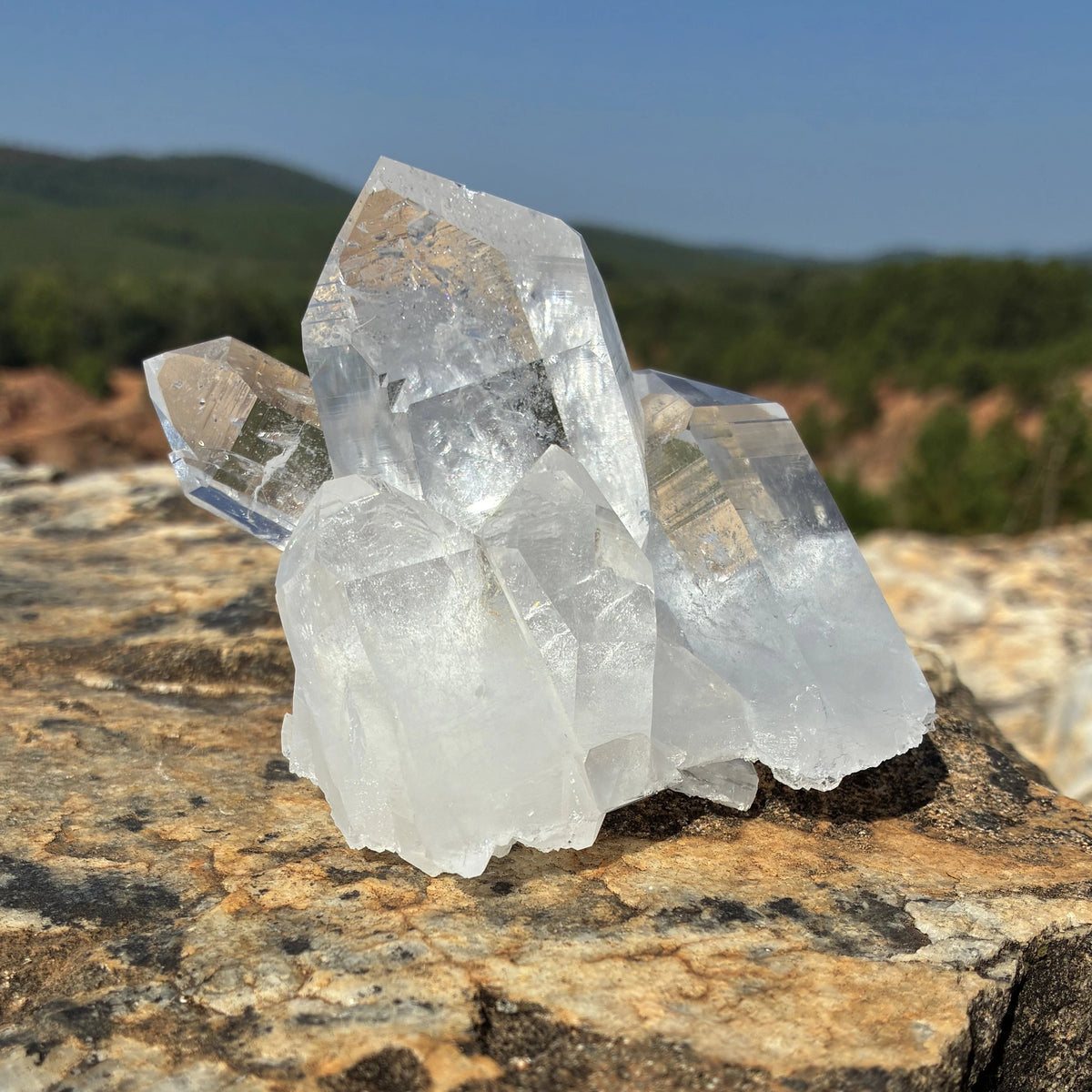 This is the left side of this quartz crystal cluster, on a rock outdoors.