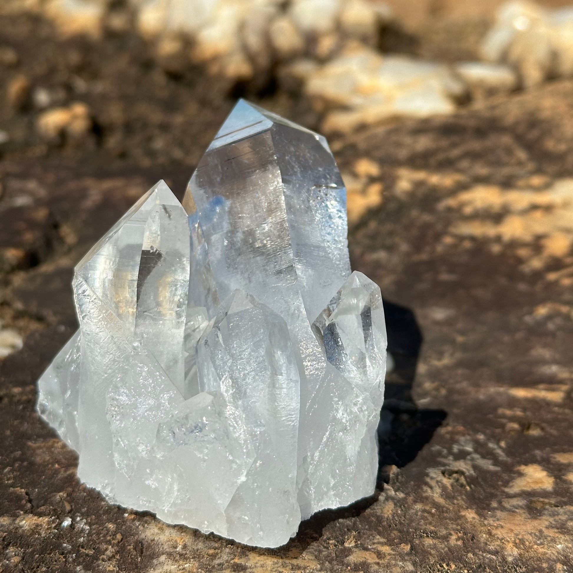 Back View Of Raw Quartz Cluster Of Crystals Sitting On A Bolder