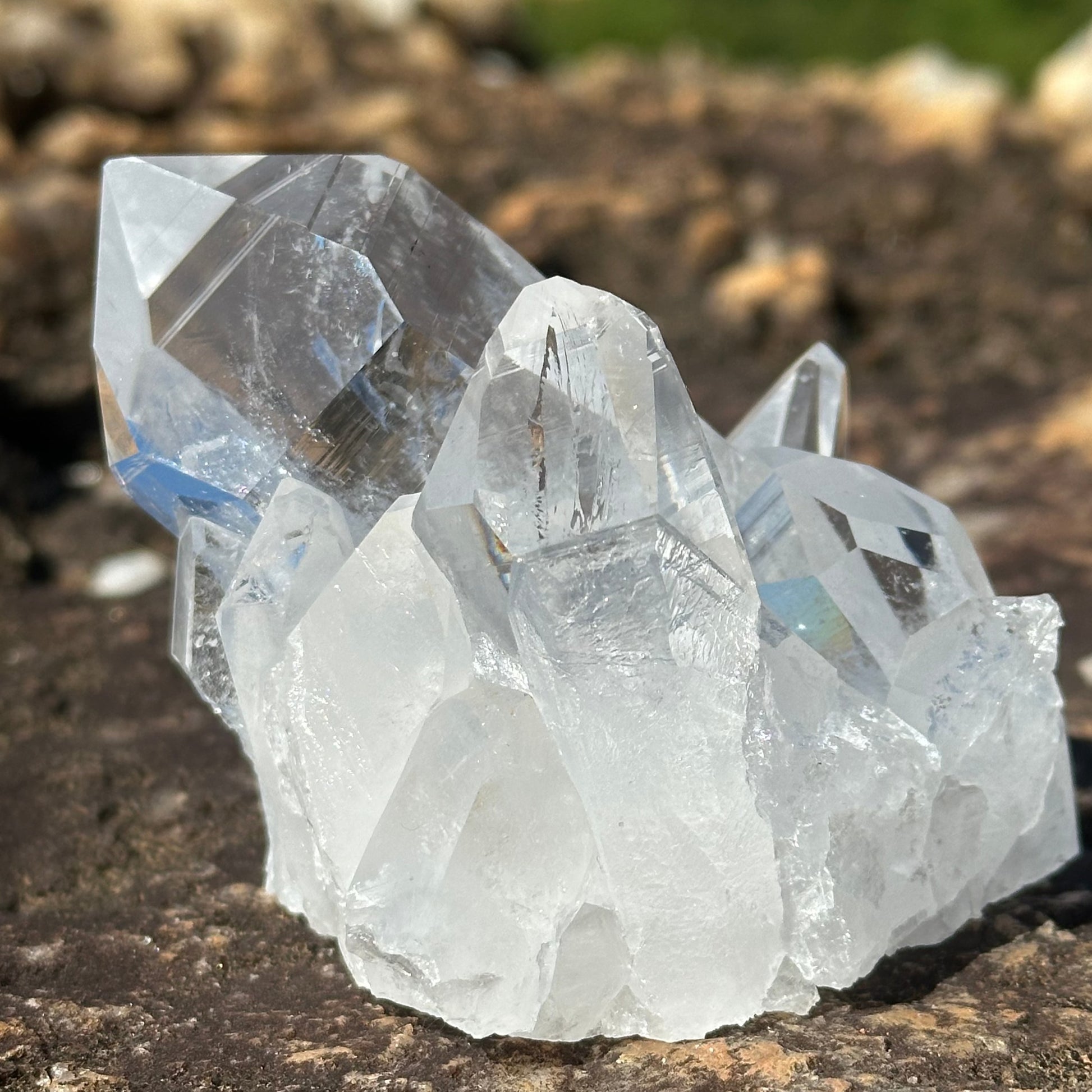 Close Up Of Thick Crystal Point On A Clear Cluster of Crystals Sitting On A Bolder