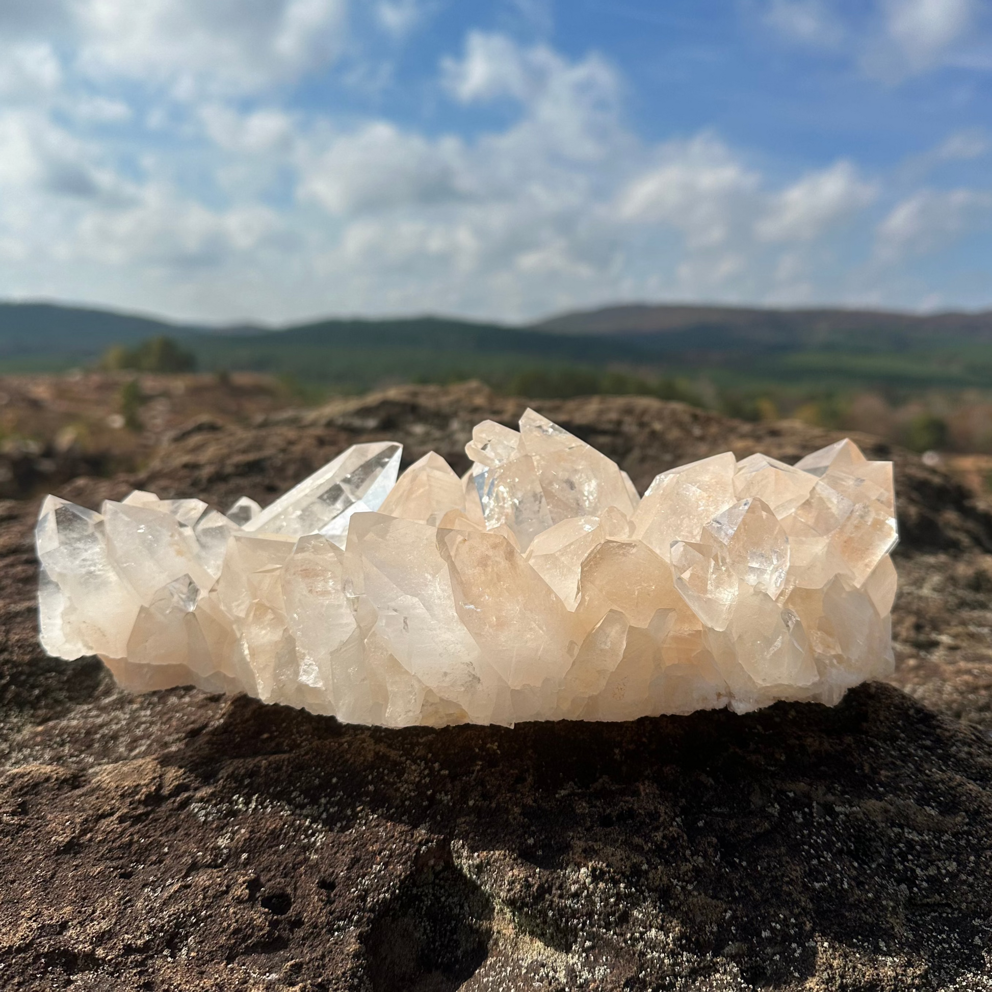 Clear Crystal Cluster On Rock With Mountains in the background