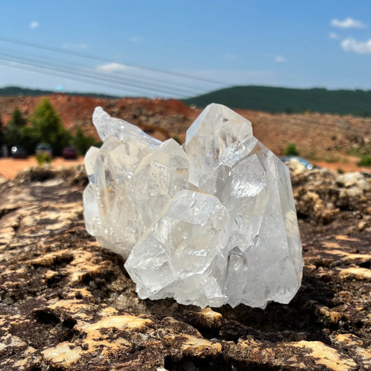 Left side of this quartz crystal cluster, in a outdoor setting.