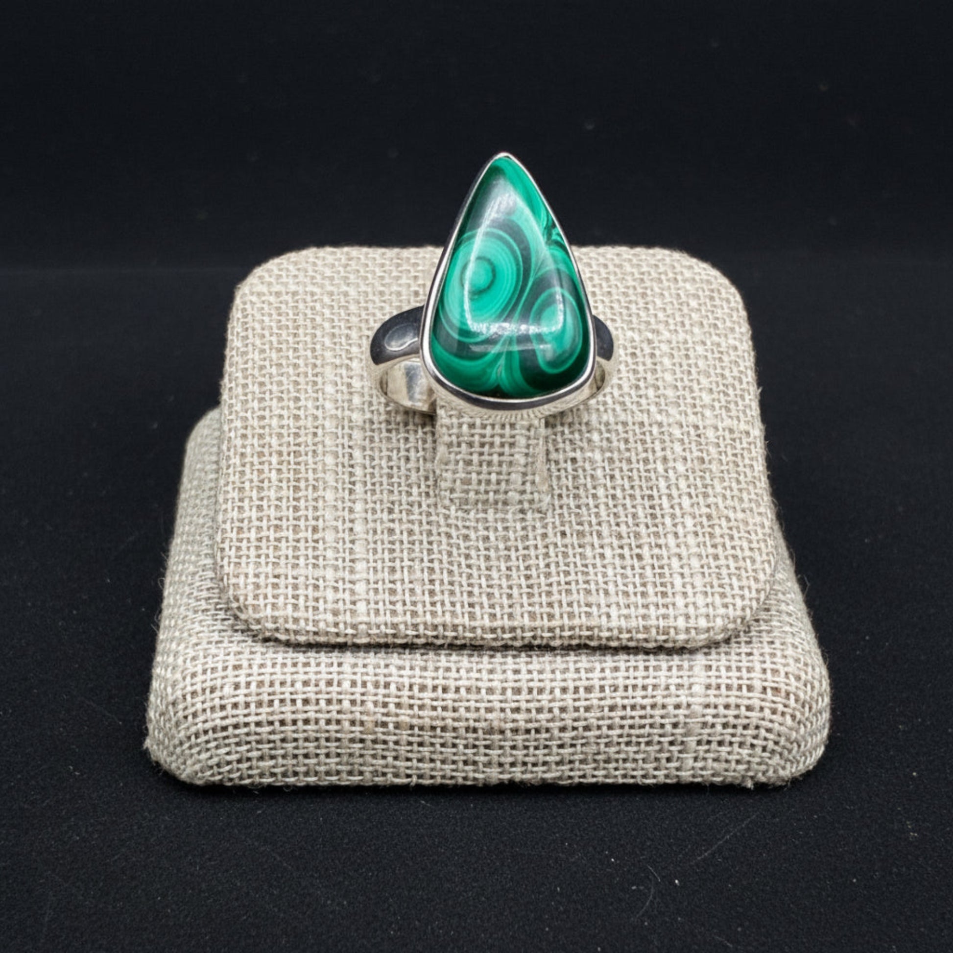 Close up of this Sterling Silver and green Malachite ring, in front of a black background.
