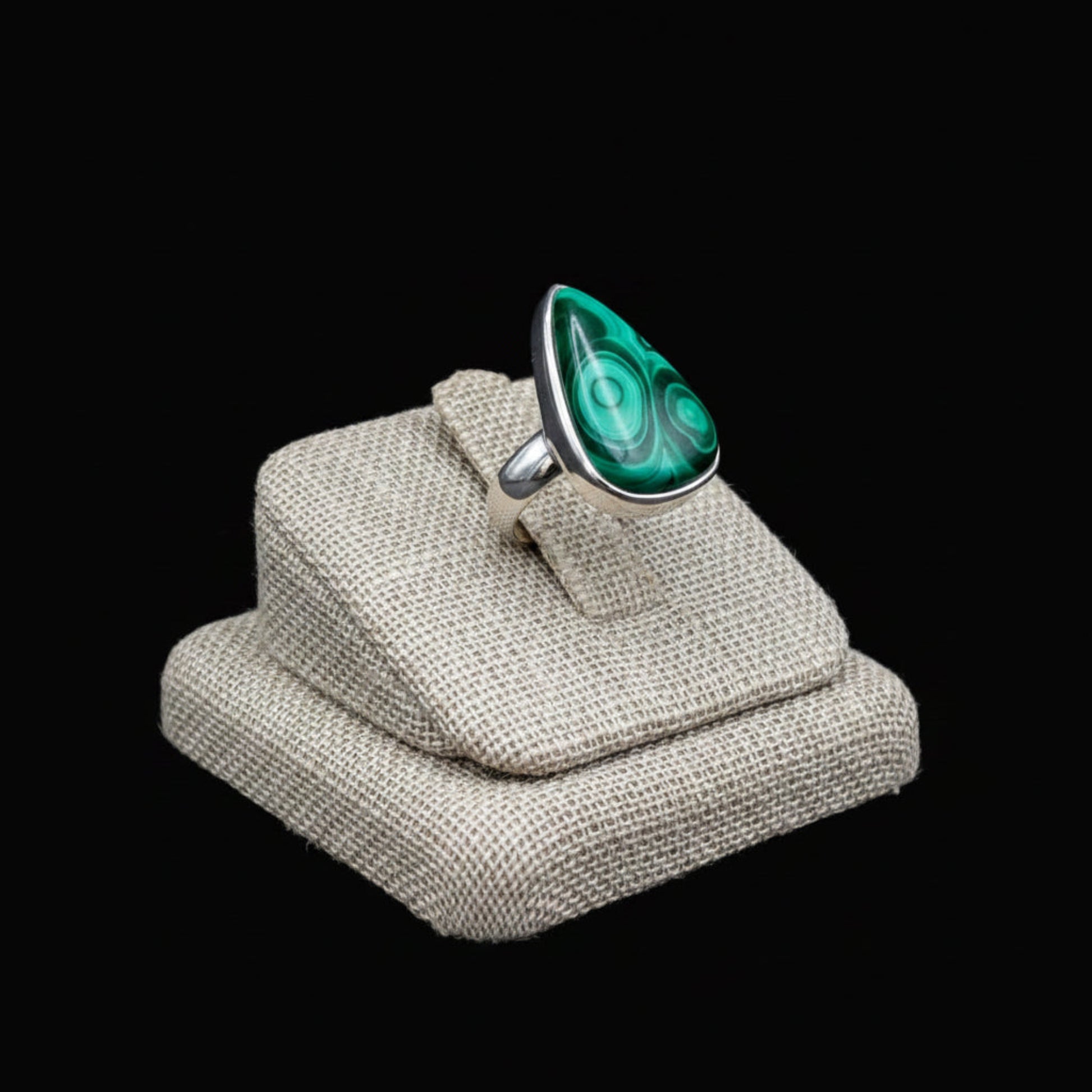 Side view of this Sterling Silver and green Malachite ring, in front of a black background.