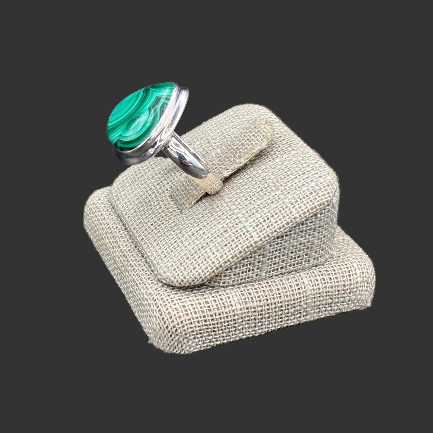 Side view of this Sterling Silver and green Malachite ring, in front of a black background.