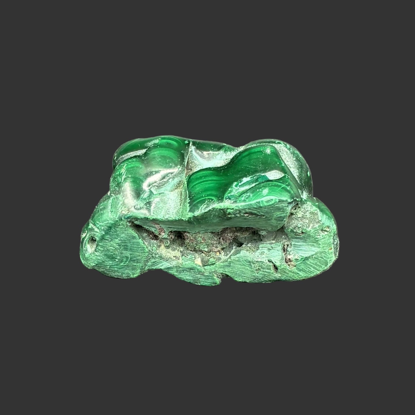 Front side of this polished green Malachite in front of a black background.