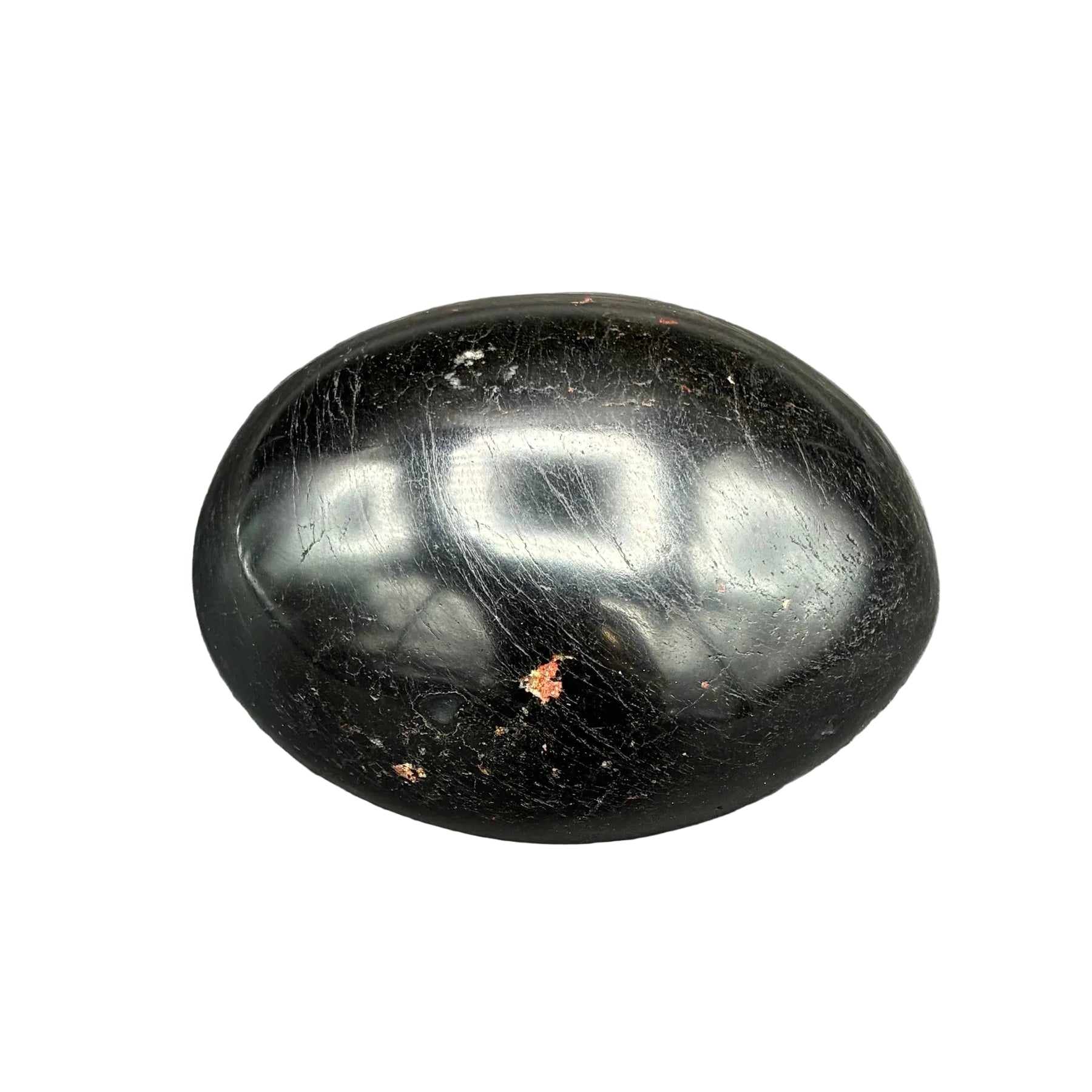 Polished oval-shaped black Tourmaline palm stone, in artificial indoor lighting.