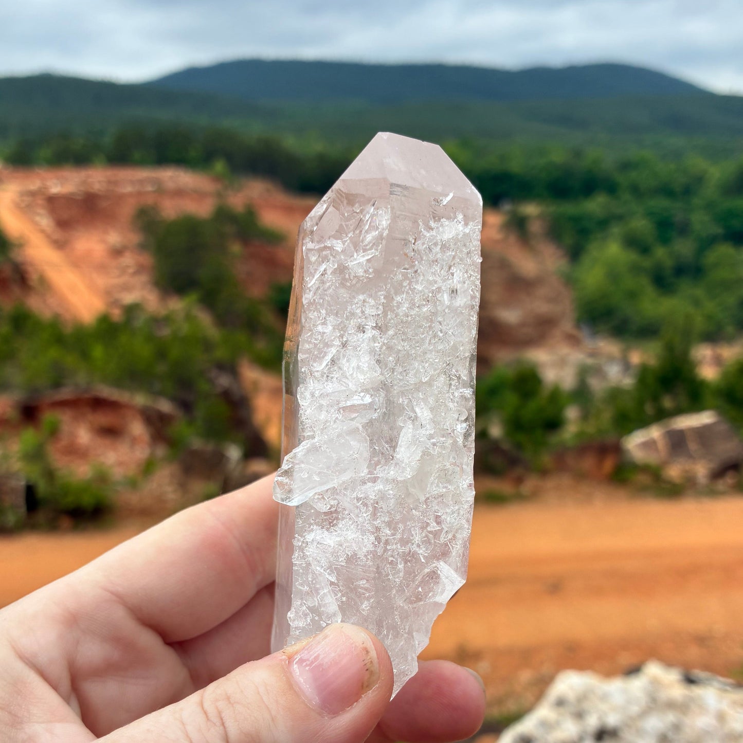 Front view of this Quartz crystal point, outdoors in front of the Ron Coleman crystal mine.