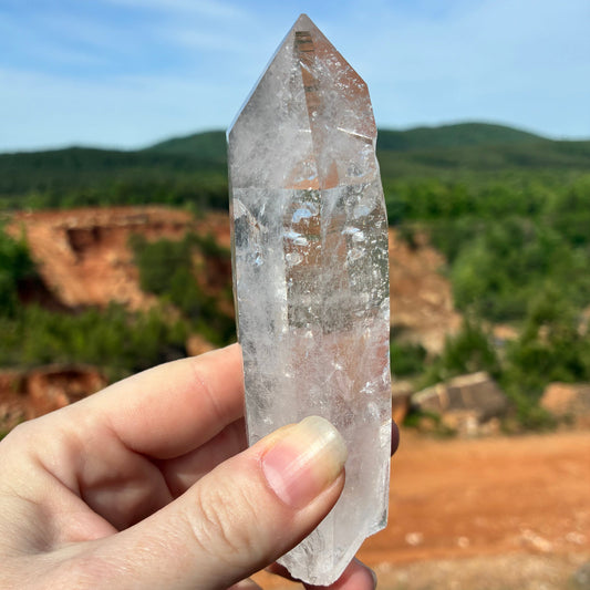 This is the front side of this single Quartz crystal point, outside in front of the crystal mine.