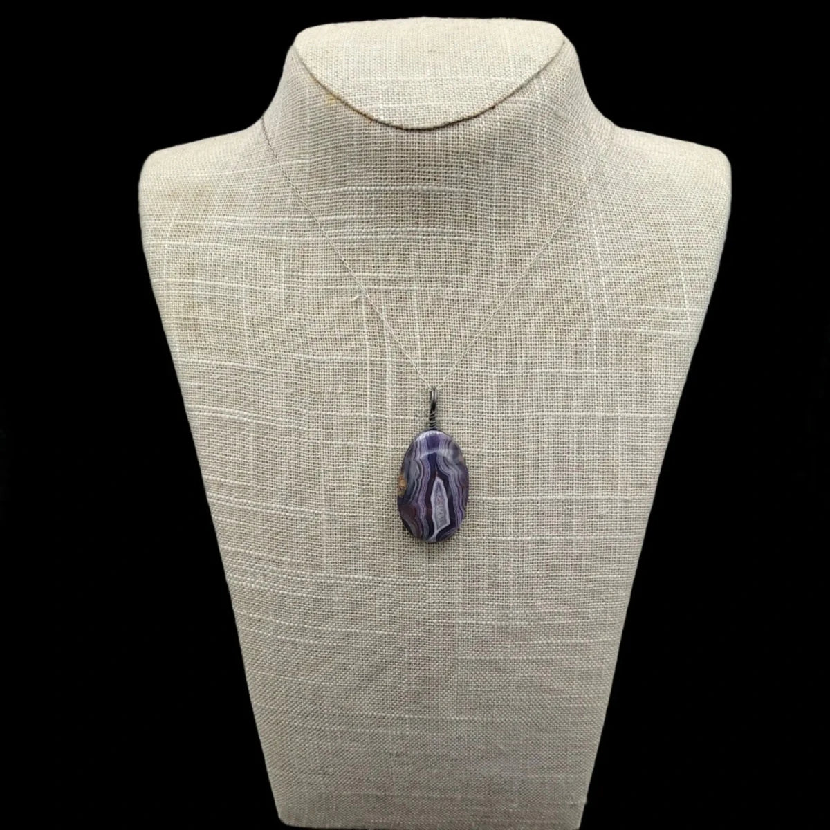 This necklace is Sterling Silver and has a wire wrapped purple Agate pendant
