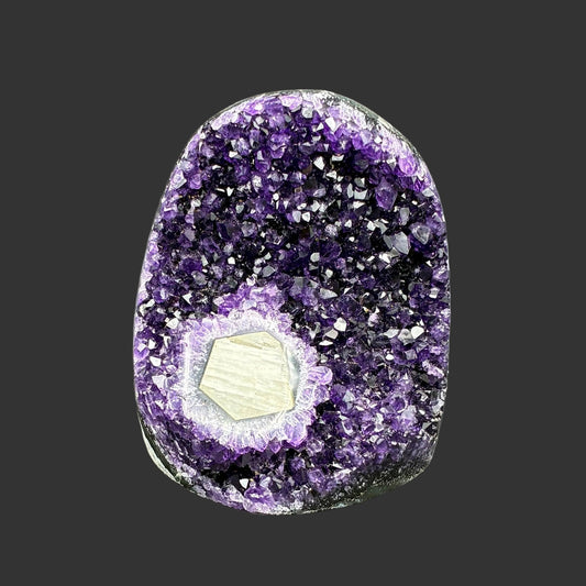 This is the front side of this dark purple Amethyst drusy cluster with Calcite, and in front of a black background.