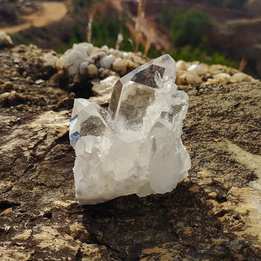From the front view of this small quartz cluster the biggest crystal point and a medium crystal point on both sides.