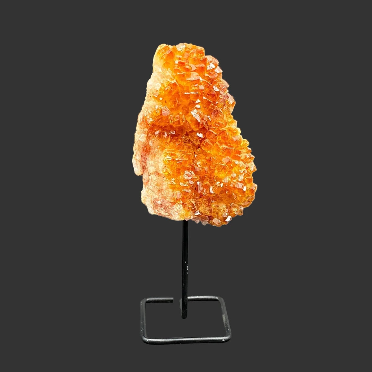 Front side of this citrine on stand, in front of a black background.