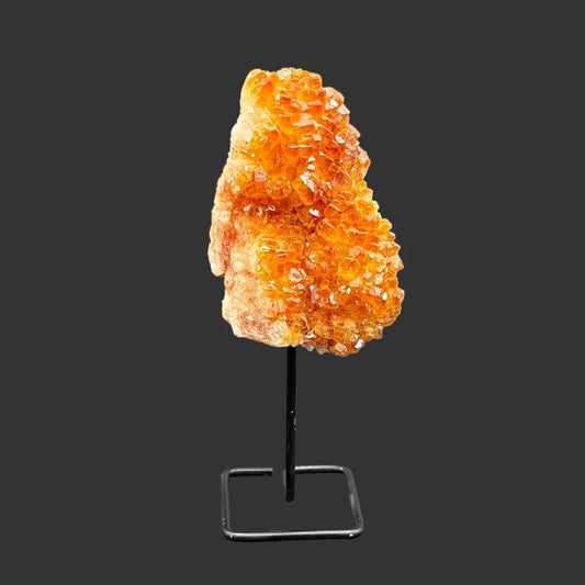 Front side of this citrine on stand, in front of a black background.