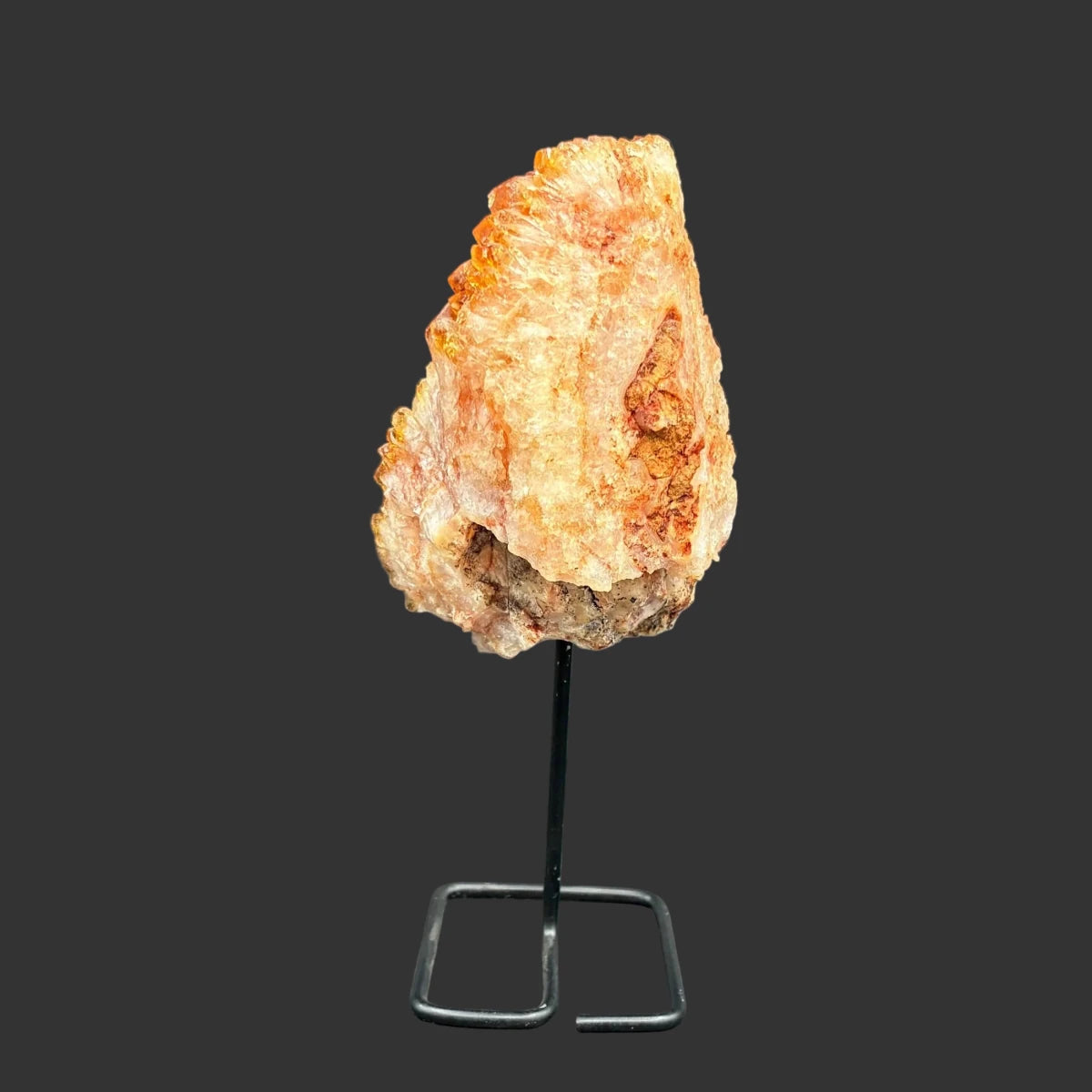 Back side of this citrine on a stand, in front of a black background.