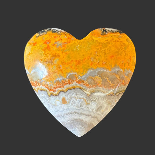 Front side of this bumblebee jasper heart, in front of a black background.