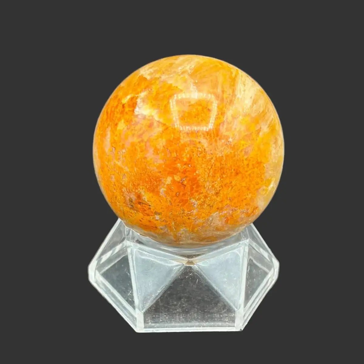 Left side of this polished Bumblebee Jasper sphere on a clear acrylic stand, in front of a black background.