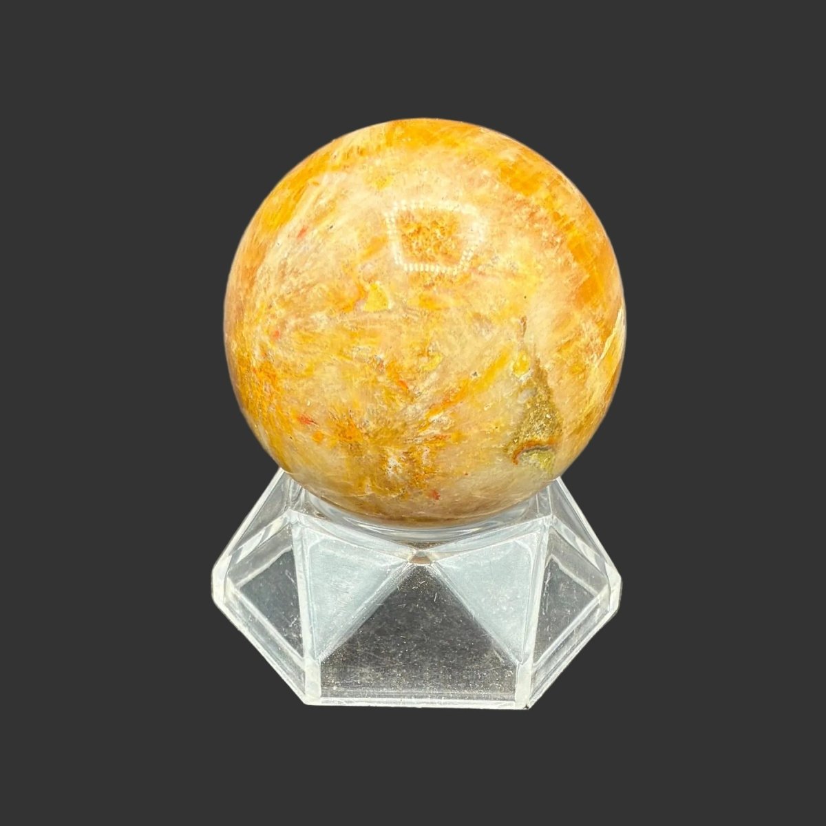 Right side of this polished Bumblebee Jasper sphere on a clear acrylic stand, in front of a black background.
