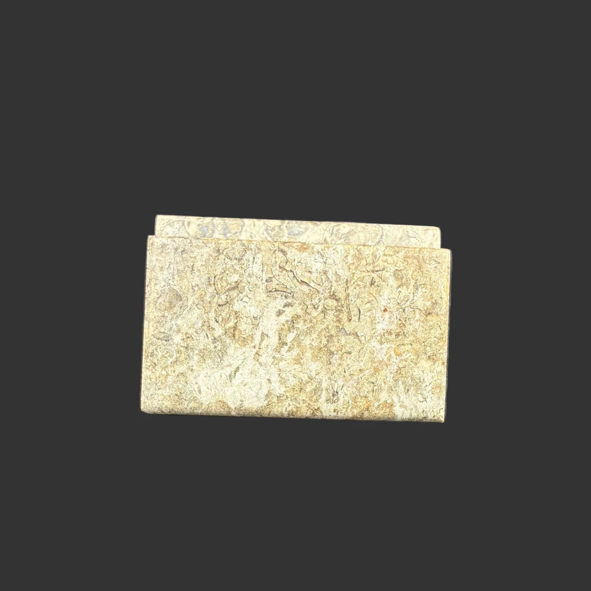 Front view of this fossil onyx card holder, in front of a black background.