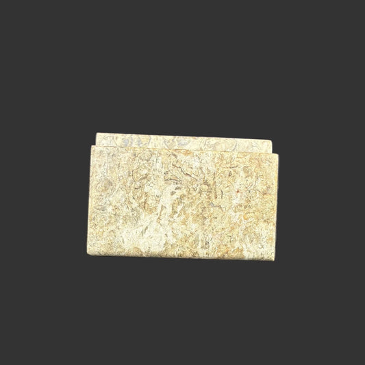 Front view of this fossil onyx card holder, in front of a black background.