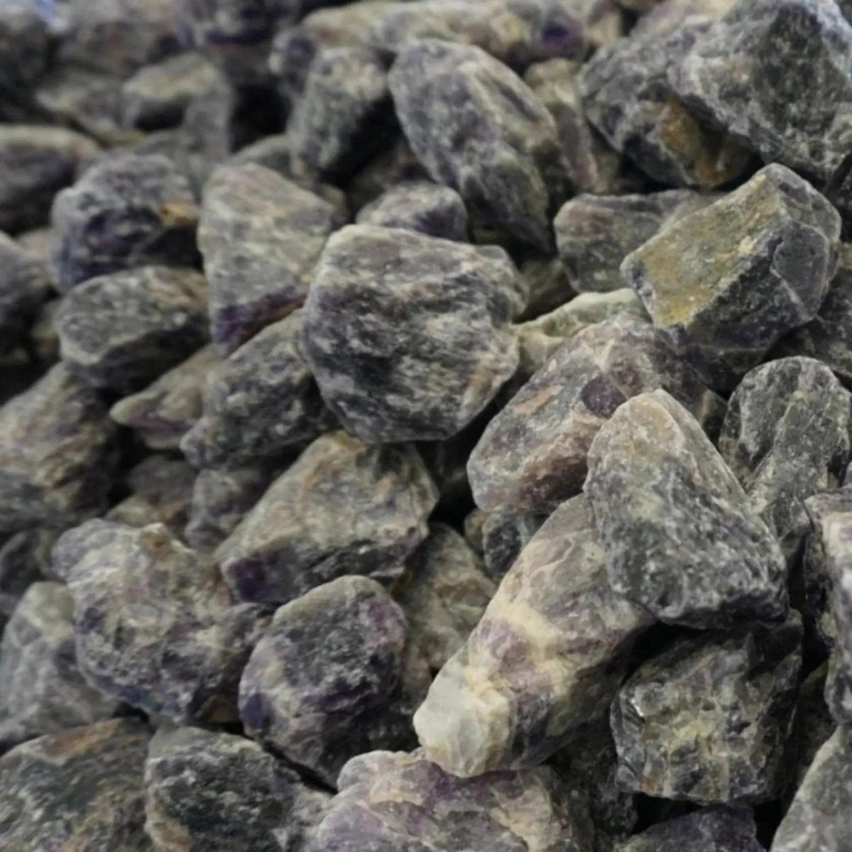 Table filled with raw Chevron Amethyst stones