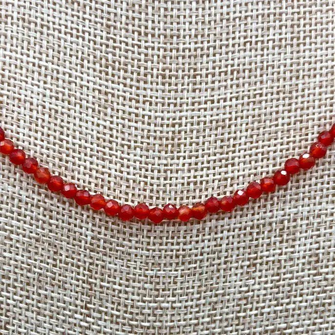 Close Up Of Faceted Red Beads On A Burlap Background