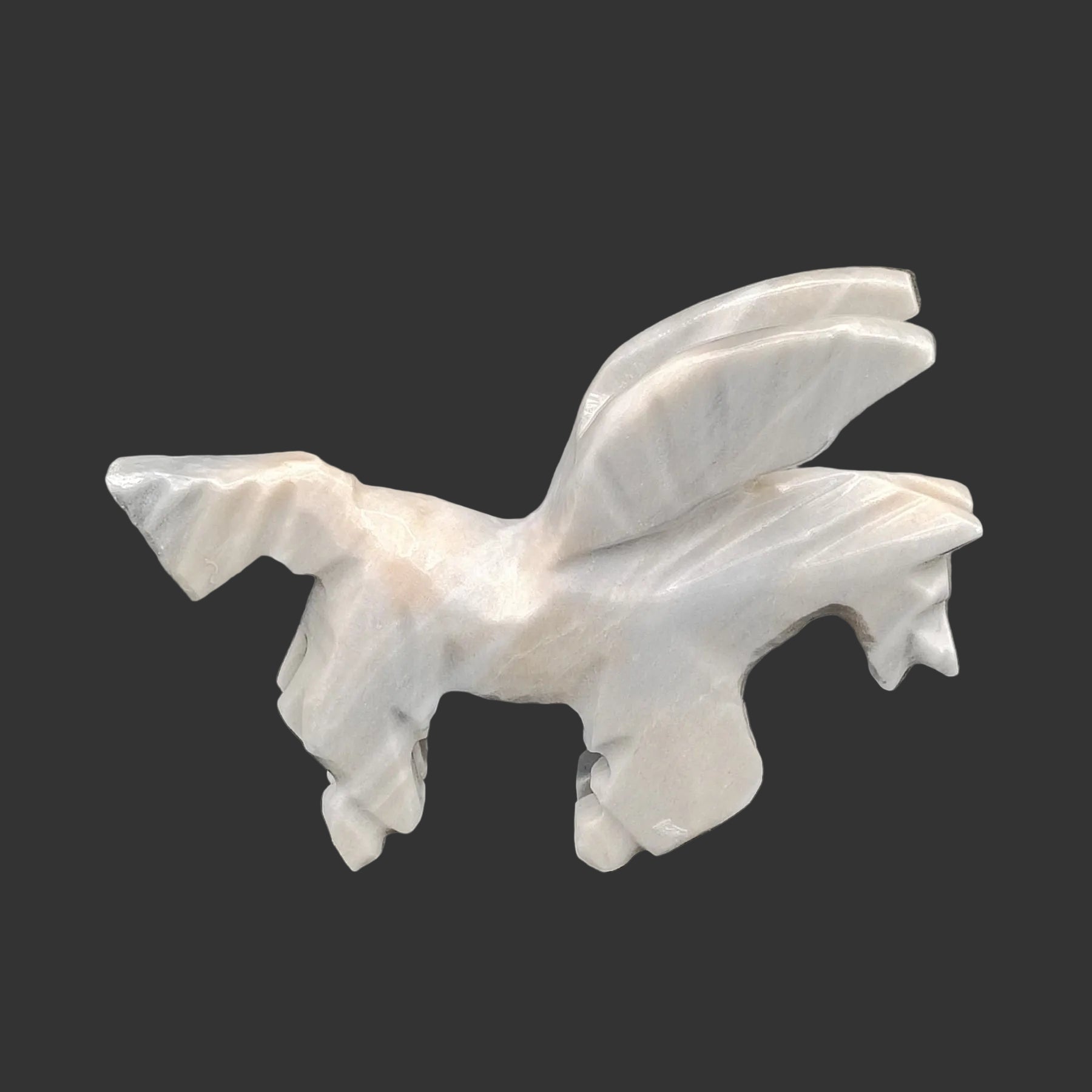 This is the right side of this grey and beige flying horse in the crouching down position.