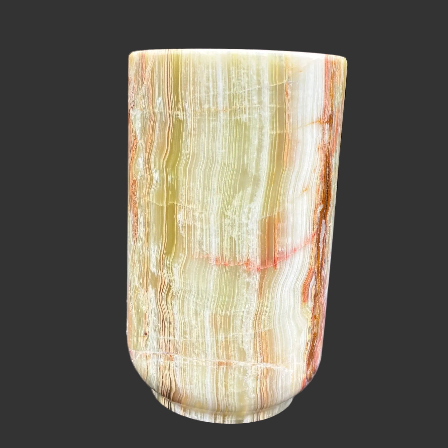 This is the front side of this multi-colored Onyx mug in front of a black background.