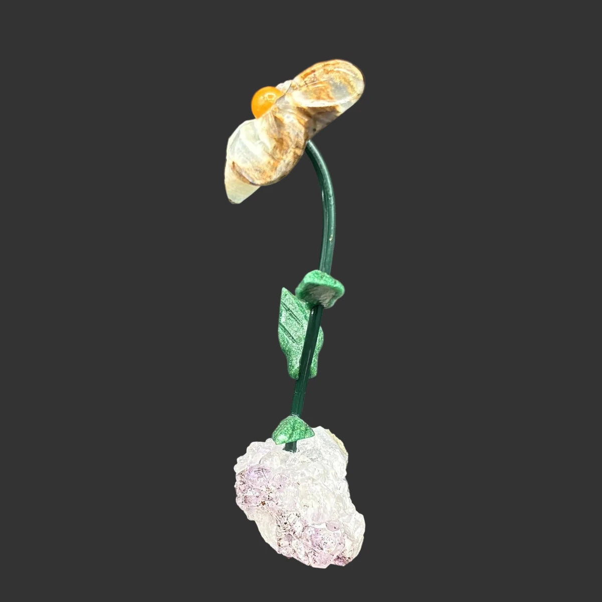 Side view of this blue onyx flower on a amethyst base, in front of a black background.