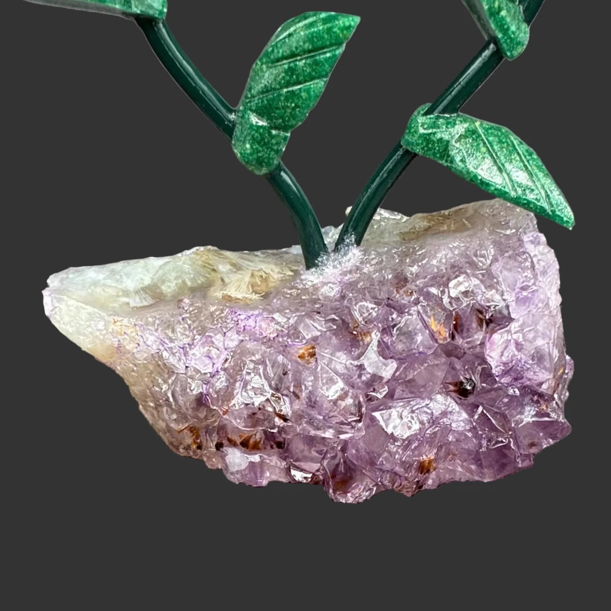 Close up of the Amethyst crystal base, in front of a black background.