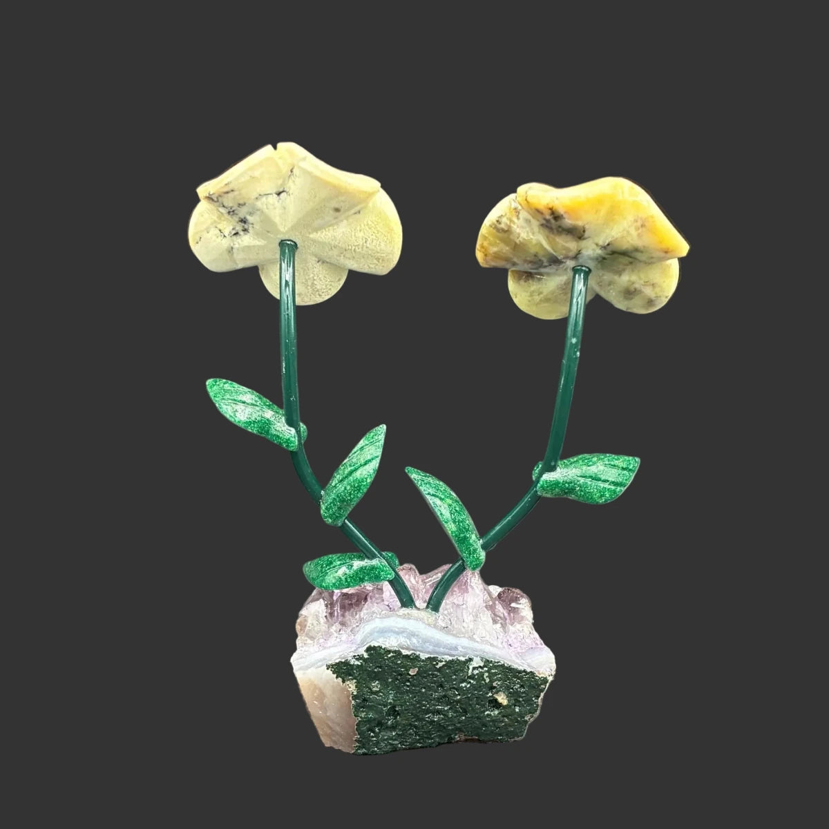 Back side of these green opal daisies' on a amethyst crystal base, in front of a black background.