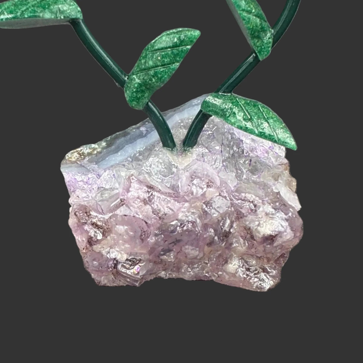 Close up of the amethyst crystal base, in front of a black background.