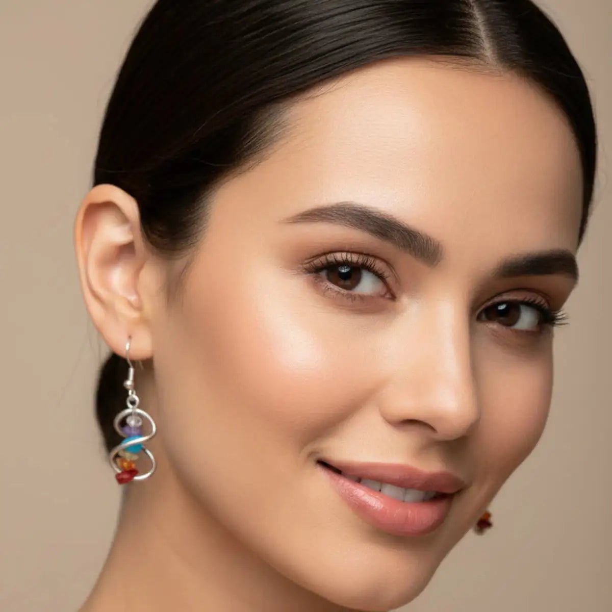 A lady wearing the chakra crystal chip infinity earrings.