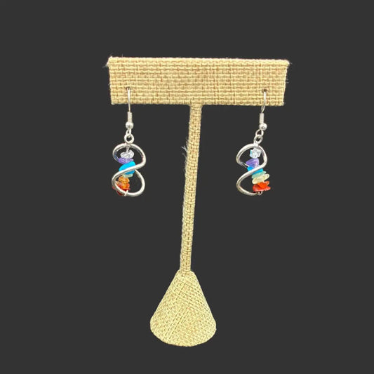 Chakra crystal chip earrings in front of a black background.