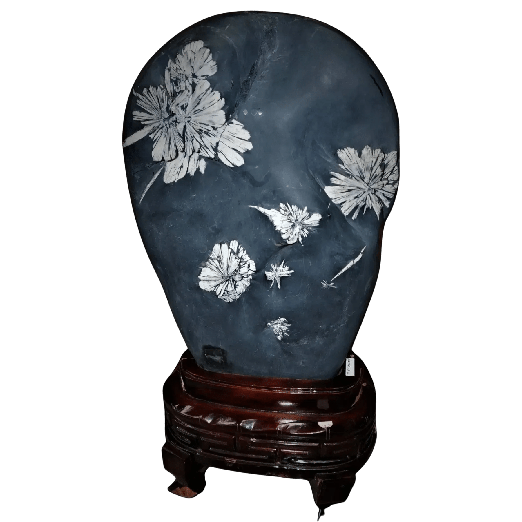 Decorative stone with floral carvings on a wooden stand against a white background