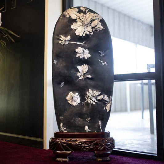 Chrysanthemum Stone On An Ornate Wood Base In Front Of A Window